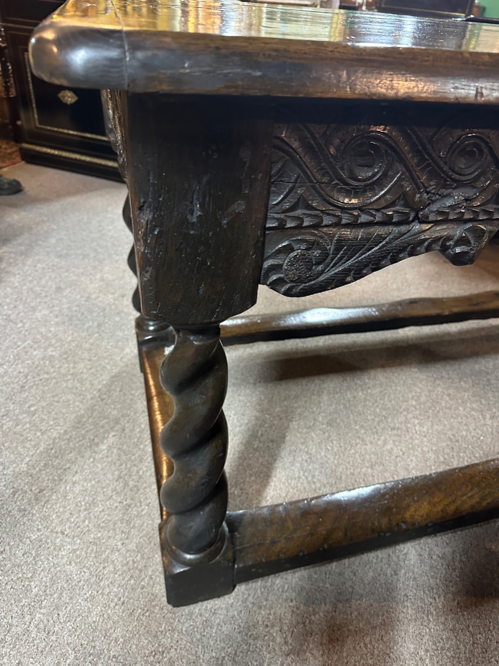 An 18th-century dark oak refectory table featuring carved apron details, spiral barley twist legs, and a perimeter stretcher base. View V