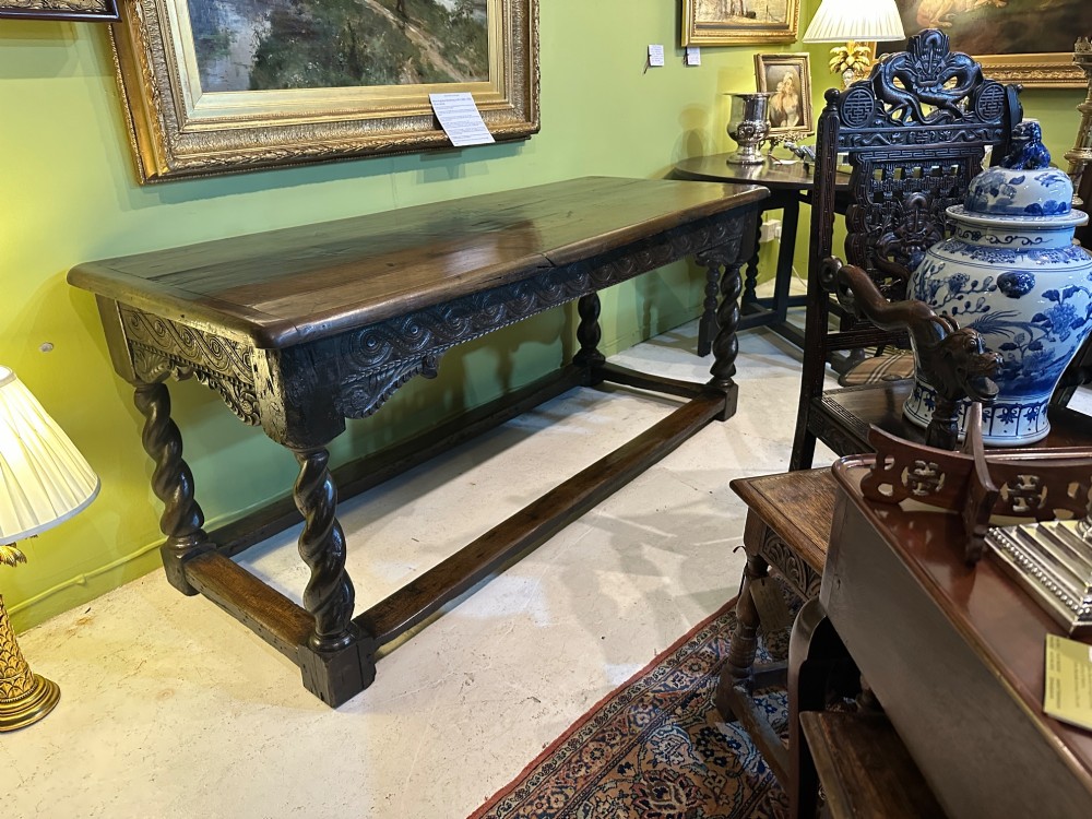 An 18th-century dark oak refectory table featuring carved apron details, spiral barley twist legs, and a perimeter stretcher base. View VII