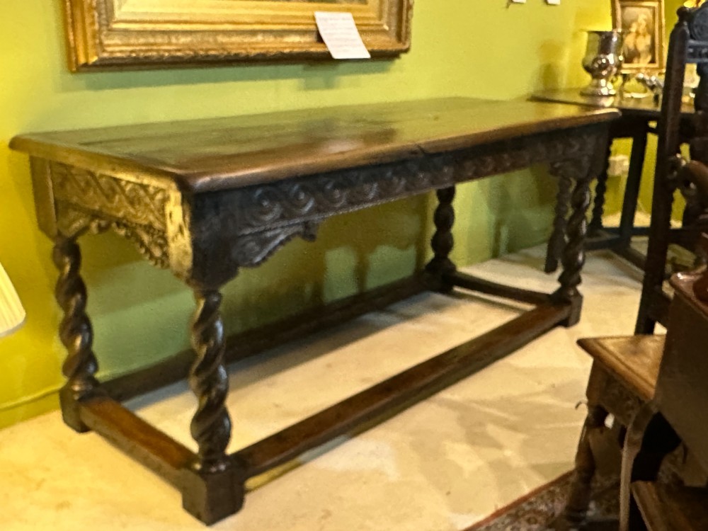 An 18th-century dark oak refectory table featuring carved apron details, spiral barley twist legs, and a perimeter stretcher base. View VIII