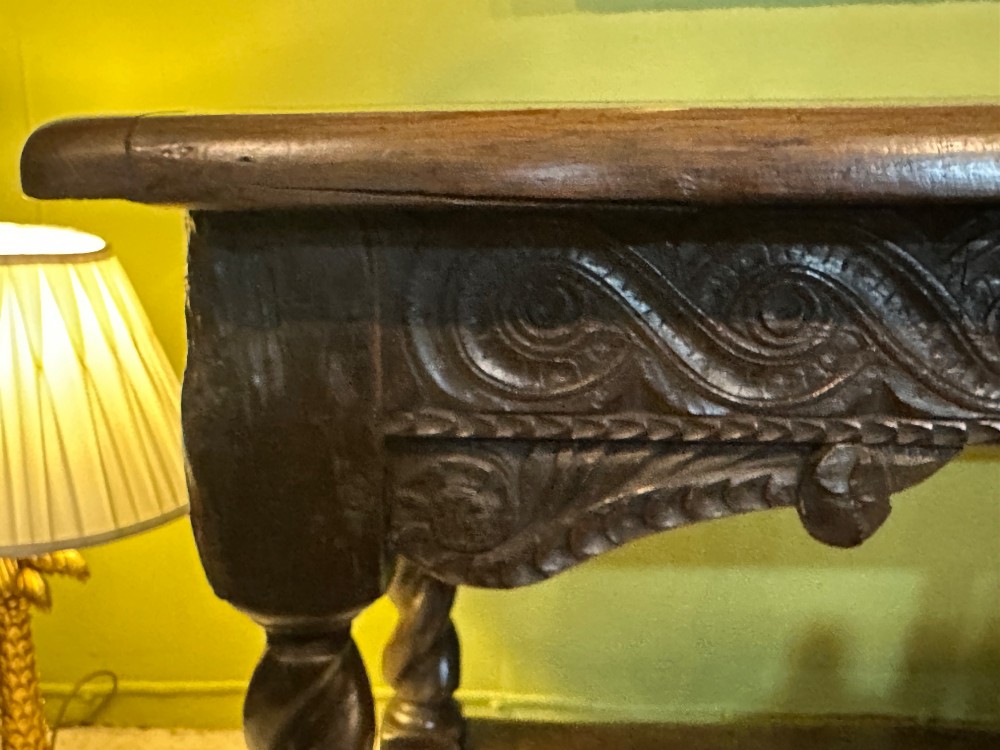 An 18th-century dark oak refectory table featuring carved apron details, spiral barley twist legs, and a perimeter stretcher base. View XI