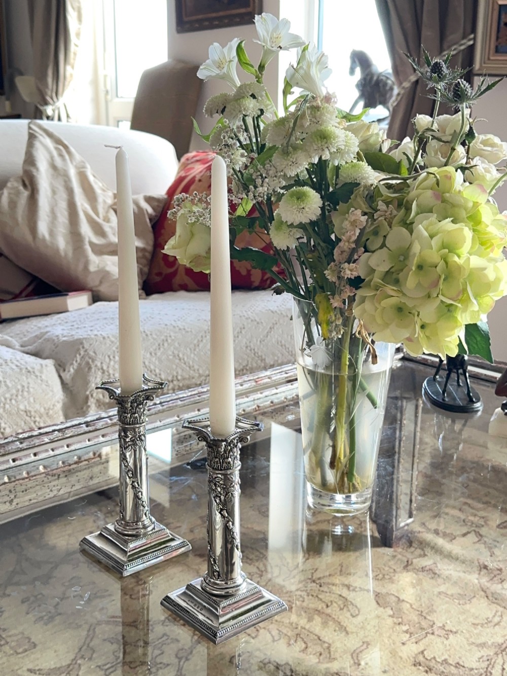 A pair of polished silver column candlesticks featuring Corinthian capitals, foliate swags, and stepped beaded bases. View III