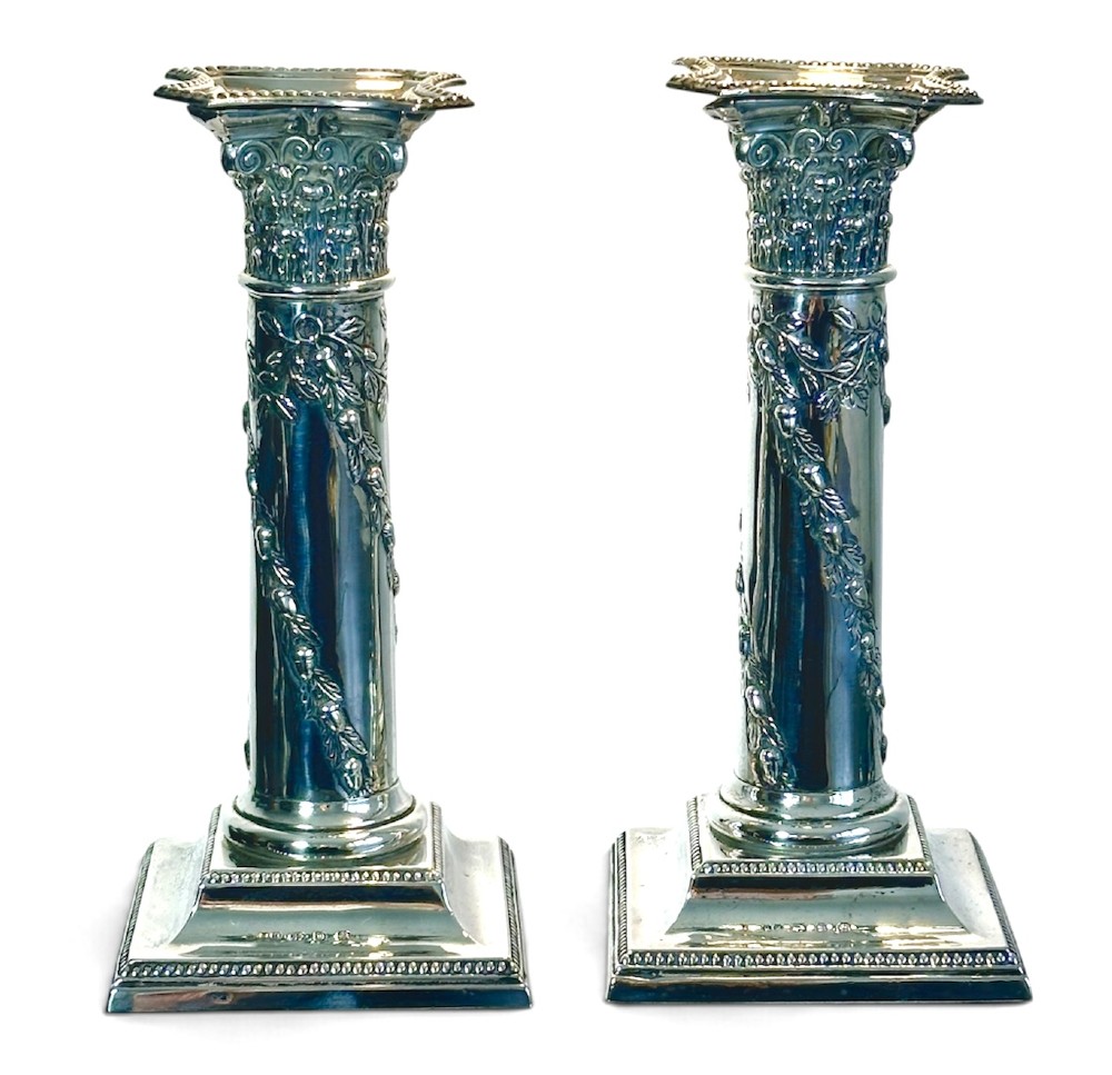 A pair of polished silver column candlesticks featuring Corinthian capitals, foliate swags, and stepped beaded bases. View IV
