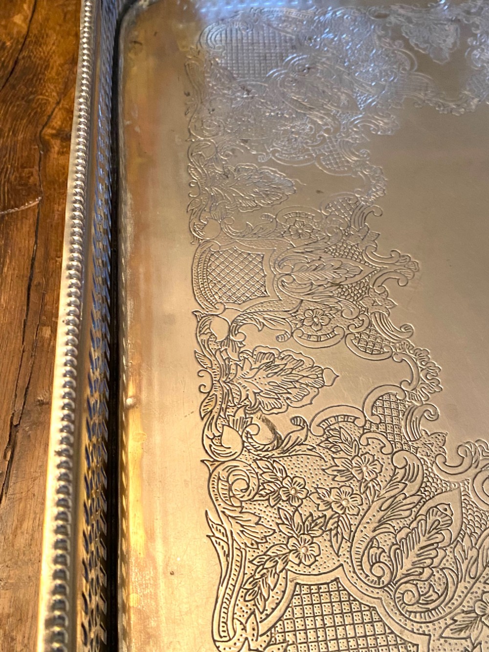 A rectangular silver-plated gallery tray featuring pierced fretwork sides, integrated oval hand-holds, an engraved surface, and ornate scrolled feet. View VII