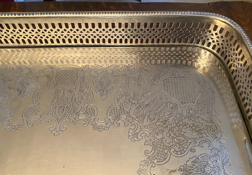 A rectangular silver-plated gallery tray featuring pierced fretwork sides, integrated oval hand-holds, an engraved surface, and ornate scrolled feet. View IX