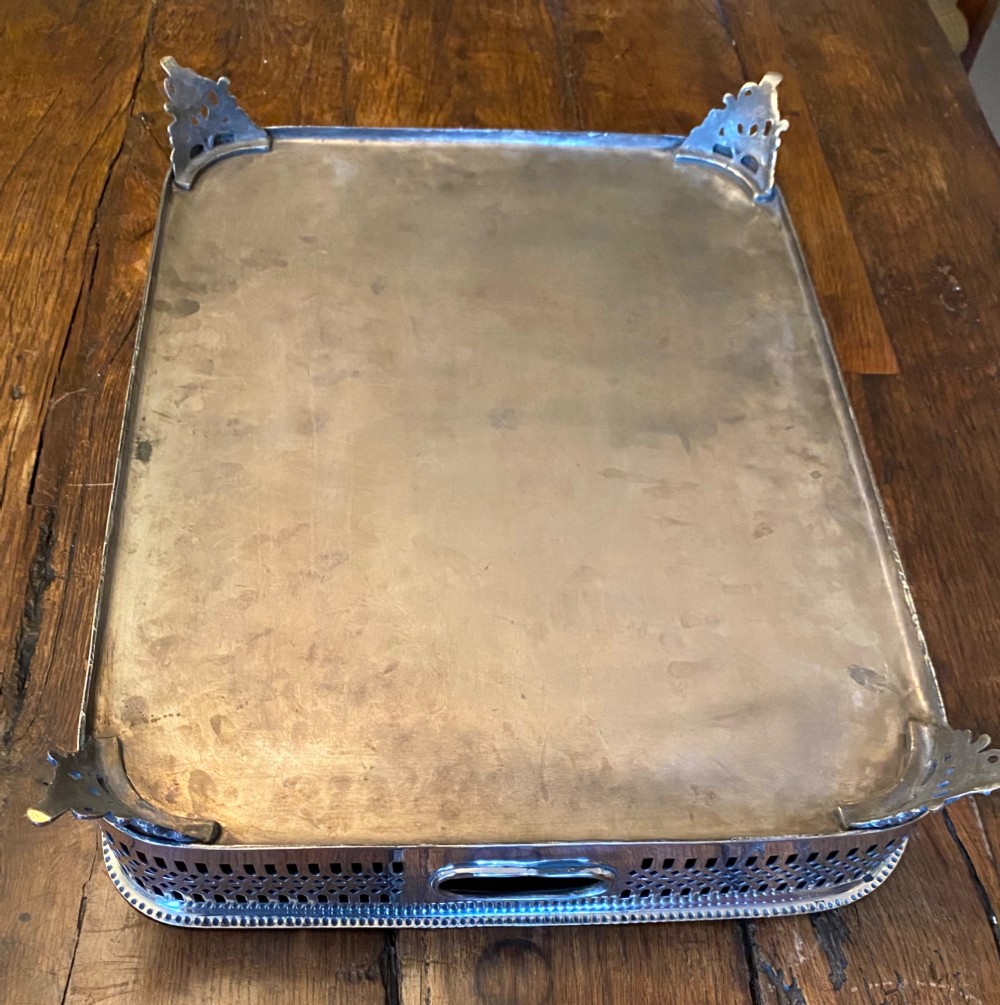 A rectangular silver-plated gallery tray featuring pierced fretwork sides, integrated oval hand-holds, an engraved surface, and ornate scrolled feet. View X