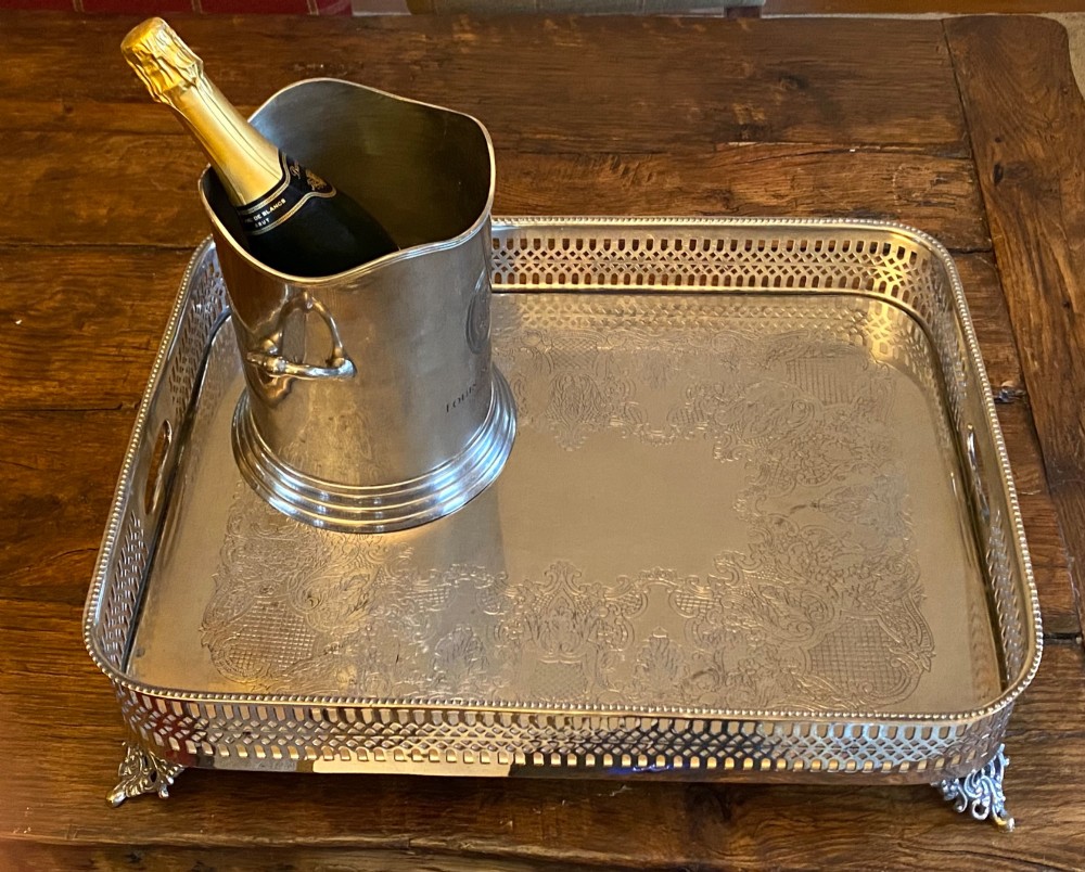 A rectangular silver-plated gallery tray featuring pierced fretwork sides, integrated oval hand-holds, an engraved surface, and ornate scrolled feet. View XII