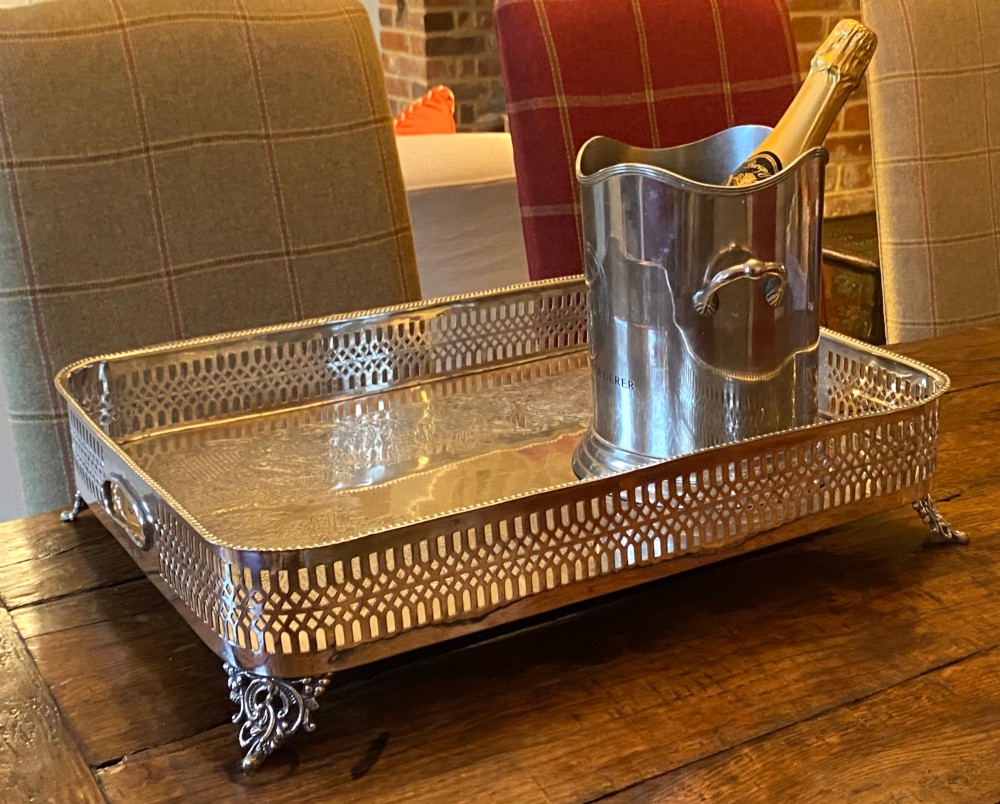 A rectangular silver-plated gallery tray featuring pierced fretwork sides, integrated oval hand-holds, an engraved surface, and ornate scrolled feet. View XIII