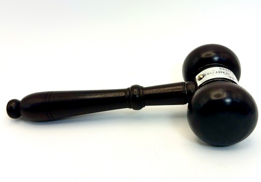 A turned dark wood ceremonial gavel featuring a central silver presentation band secured with small screws.