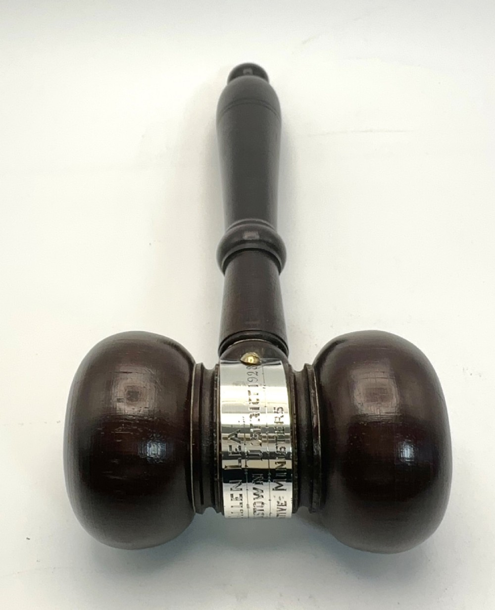 A turned dark wood ceremonial gavel featuring a central silver presentation band secured with small screws. View II