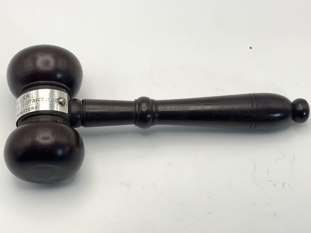 A turned dark wood ceremonial gavel featuring a central silver presentation band secured with small screws. View VI