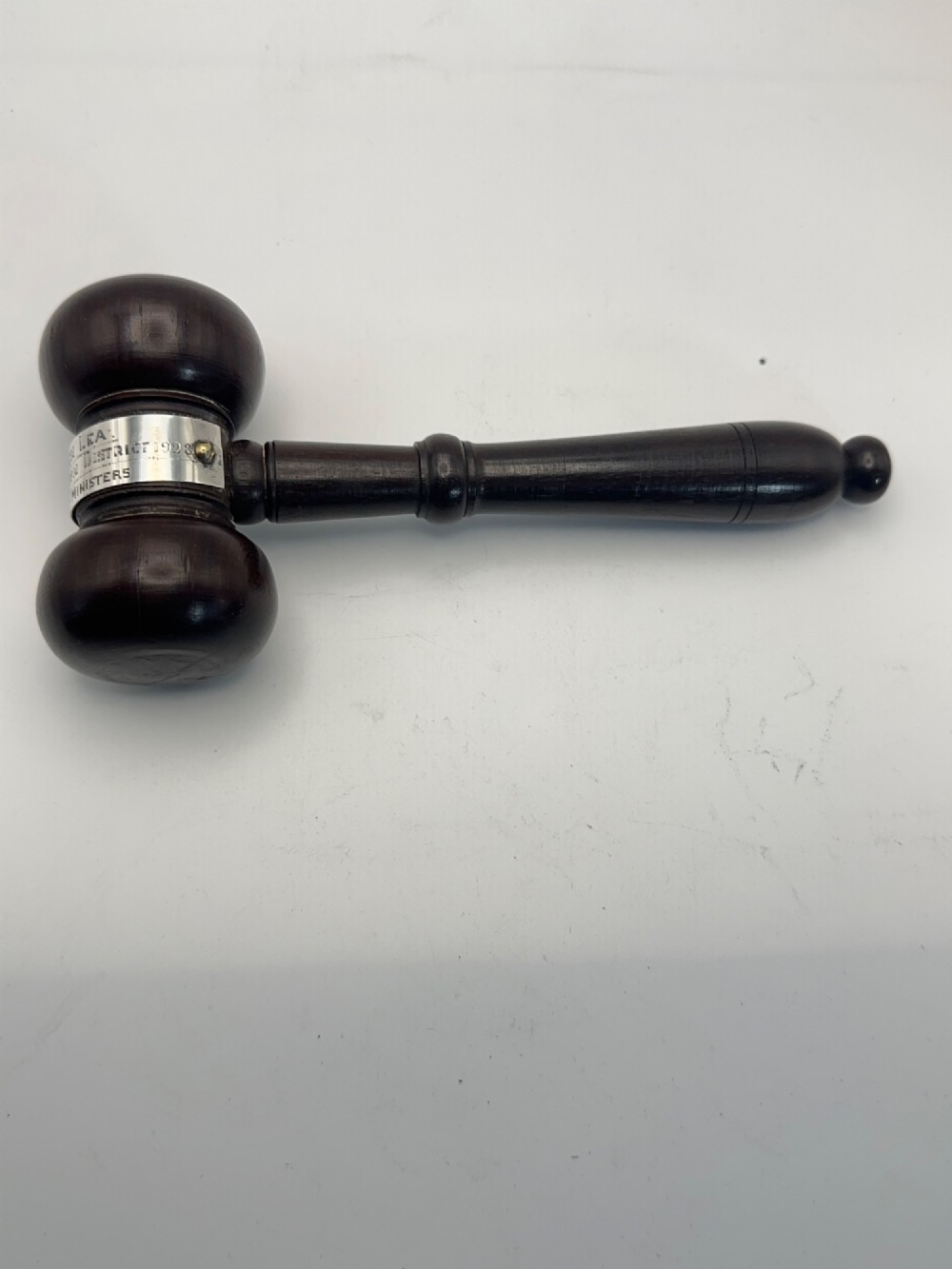 A turned dark wood ceremonial gavel featuring a central silver presentation band secured with small screws. View VII