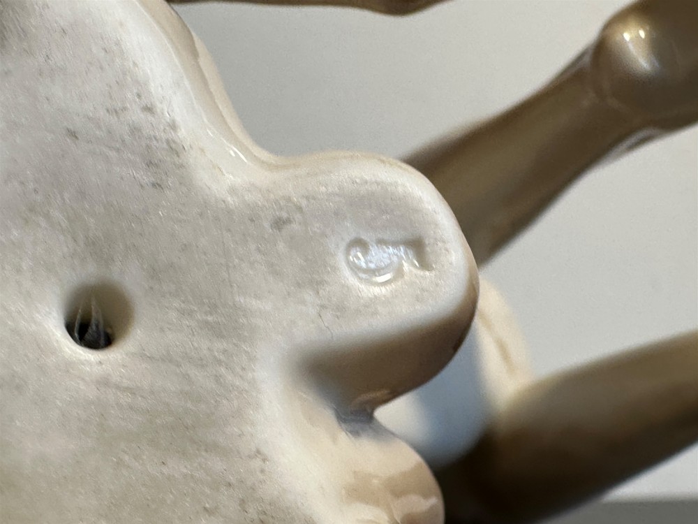 A glazed fawn-coloured Nymphenburg porcelain figurine depicting a seated Great Dane with erect ears and a black muzzle. View X