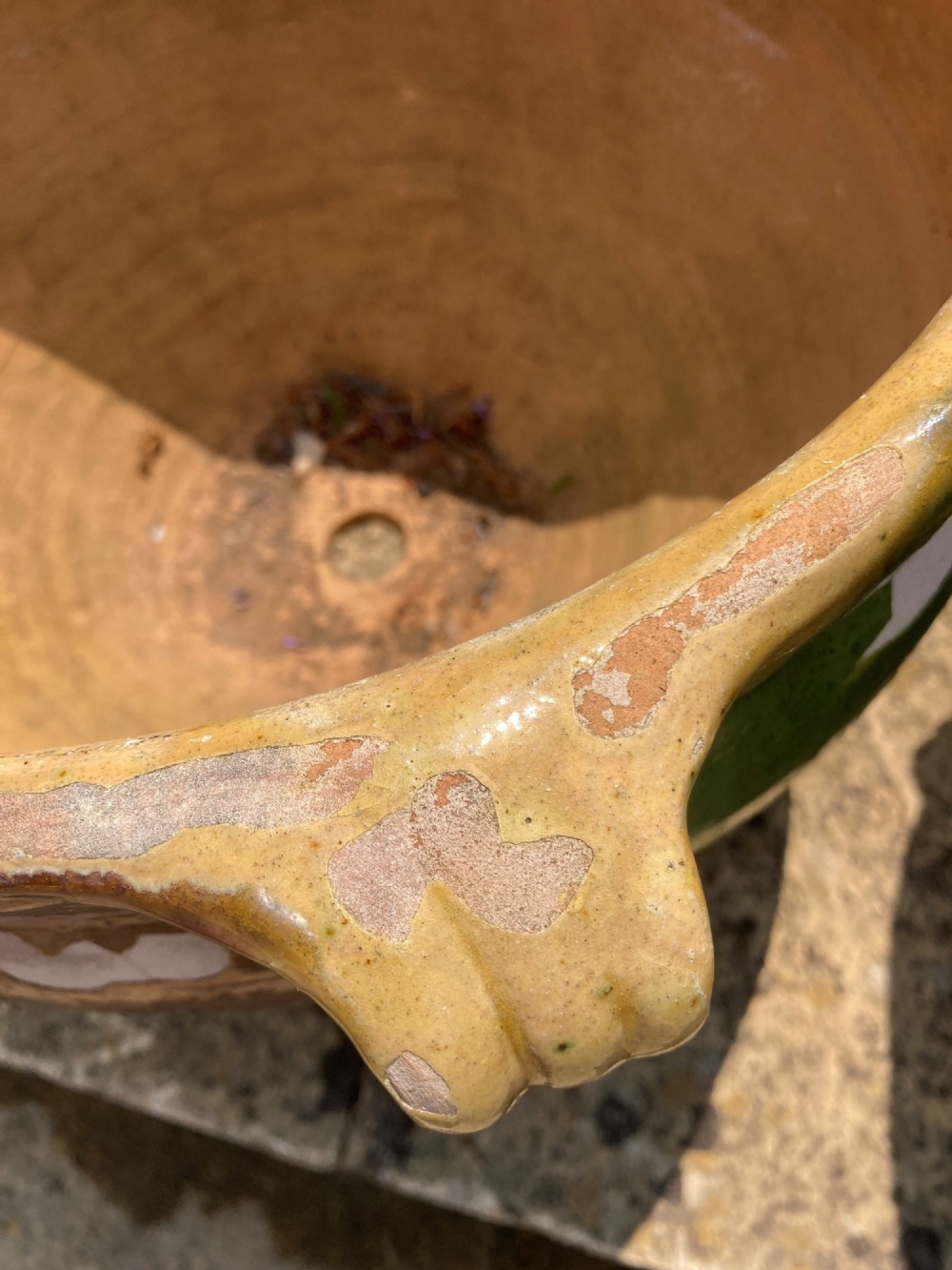 A pair of round ochre yellow terracotta planters featuring green and brown drip glaze patterns and twin looped side handles. View II