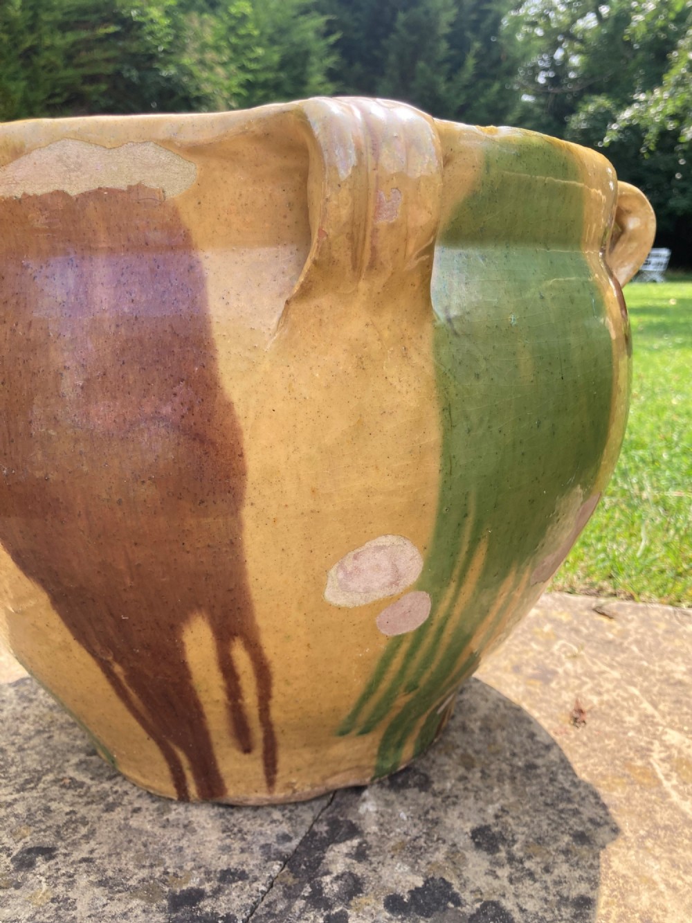 A pair of round ochre yellow terracotta planters featuring green and brown drip glaze patterns and twin looped side handles. View V