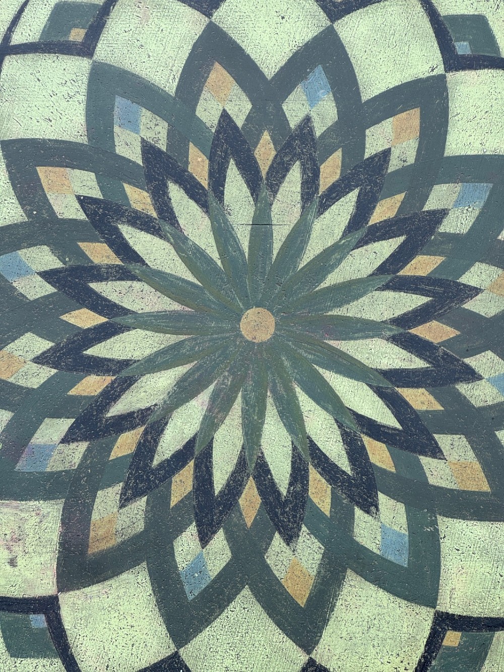 A Victorian circular tilt-top side table featuring hand-painted geometric patterns in sage green, olive, and cream resting on a turned stem with tripod legs. View IV