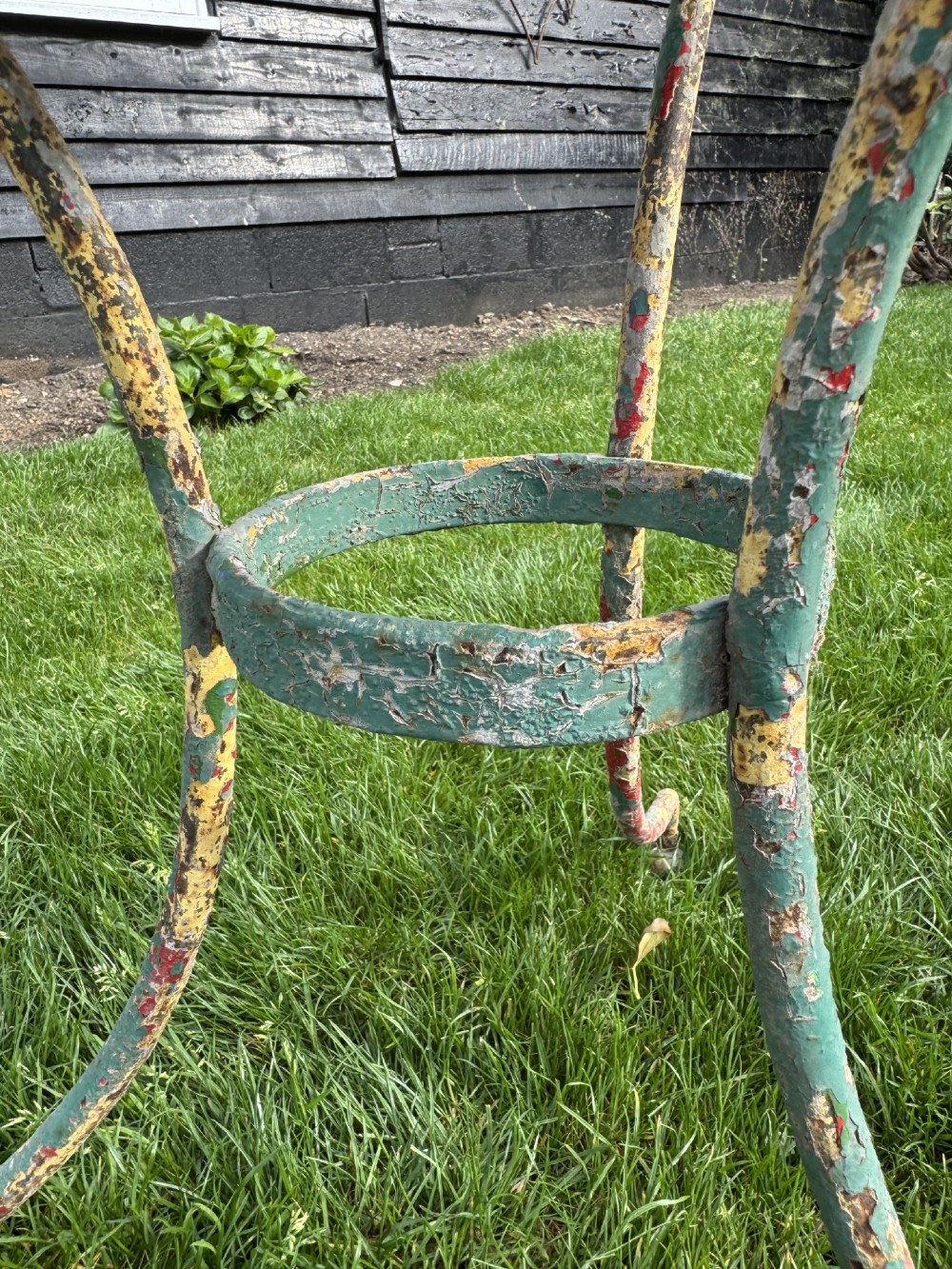 A weathered green painted wrought iron bistro set featuring a round pedestal table and two hoop-back chairs with lattice seats. View IV