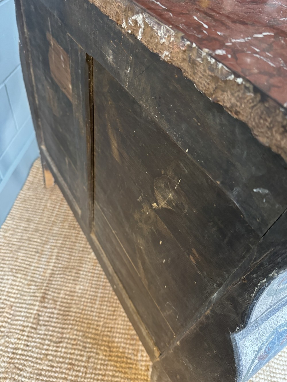 A nineteenth-century French bombee chest of drawers featuring a later hand-painted pattern, a dark marble top, and ornate gilt bronze mounts. View XIII