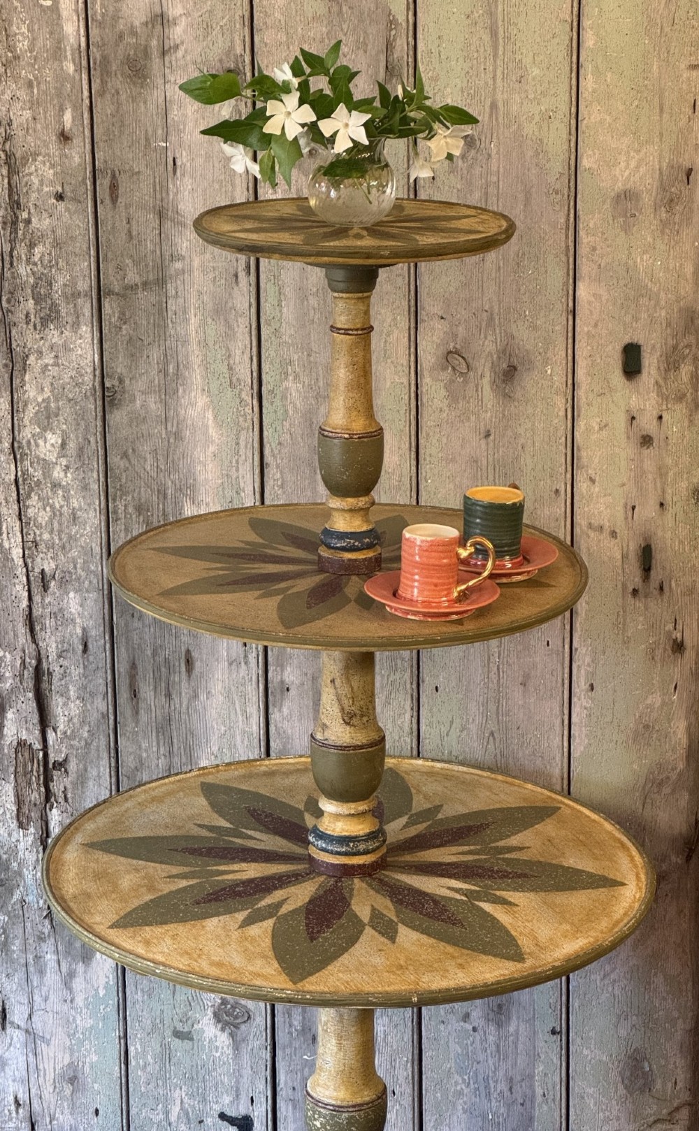 A Victorian three-tier wooden pedestal table with a painted finish, turned central stem, starburst motif, and tripod feet. View III