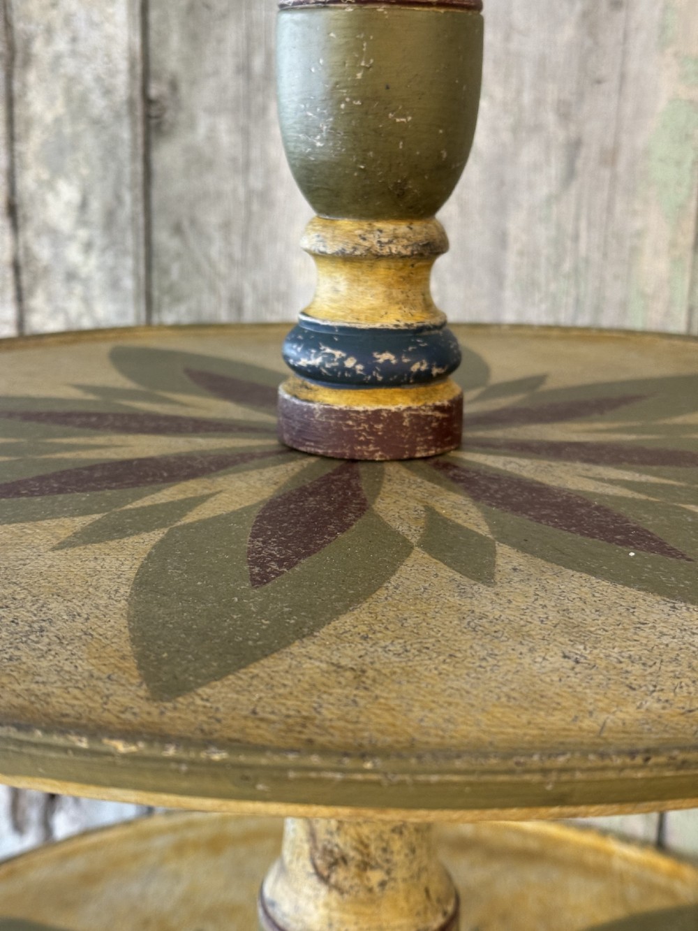 A Victorian three-tier wooden pedestal table with a painted finish, turned central stem, starburst motif, and tripod feet. View IV