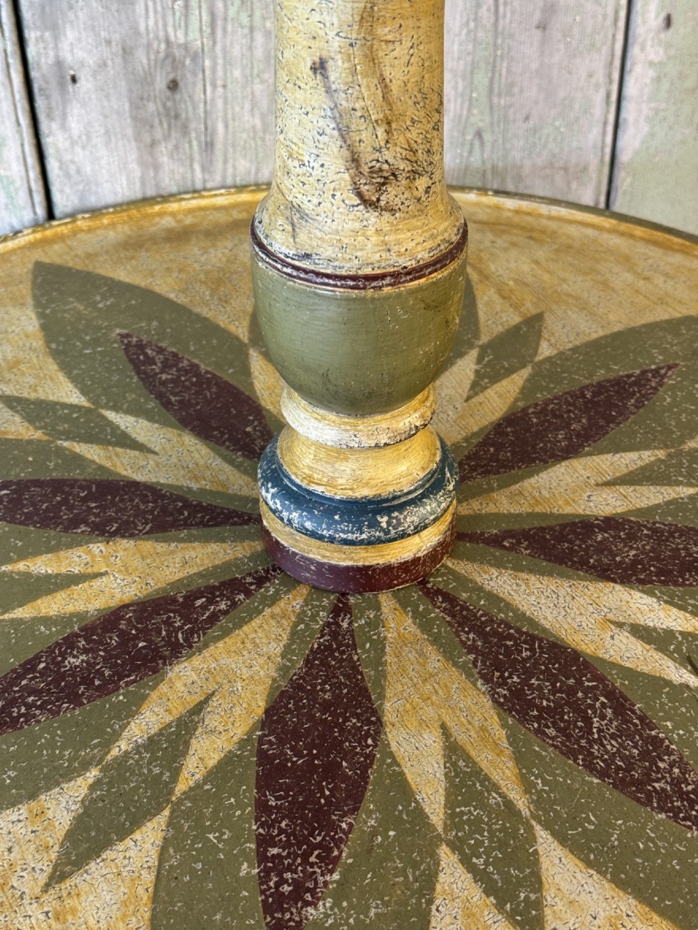 A Victorian three-tier wooden pedestal table with a painted finish, turned central stem, starburst motif, and tripod feet. View VI