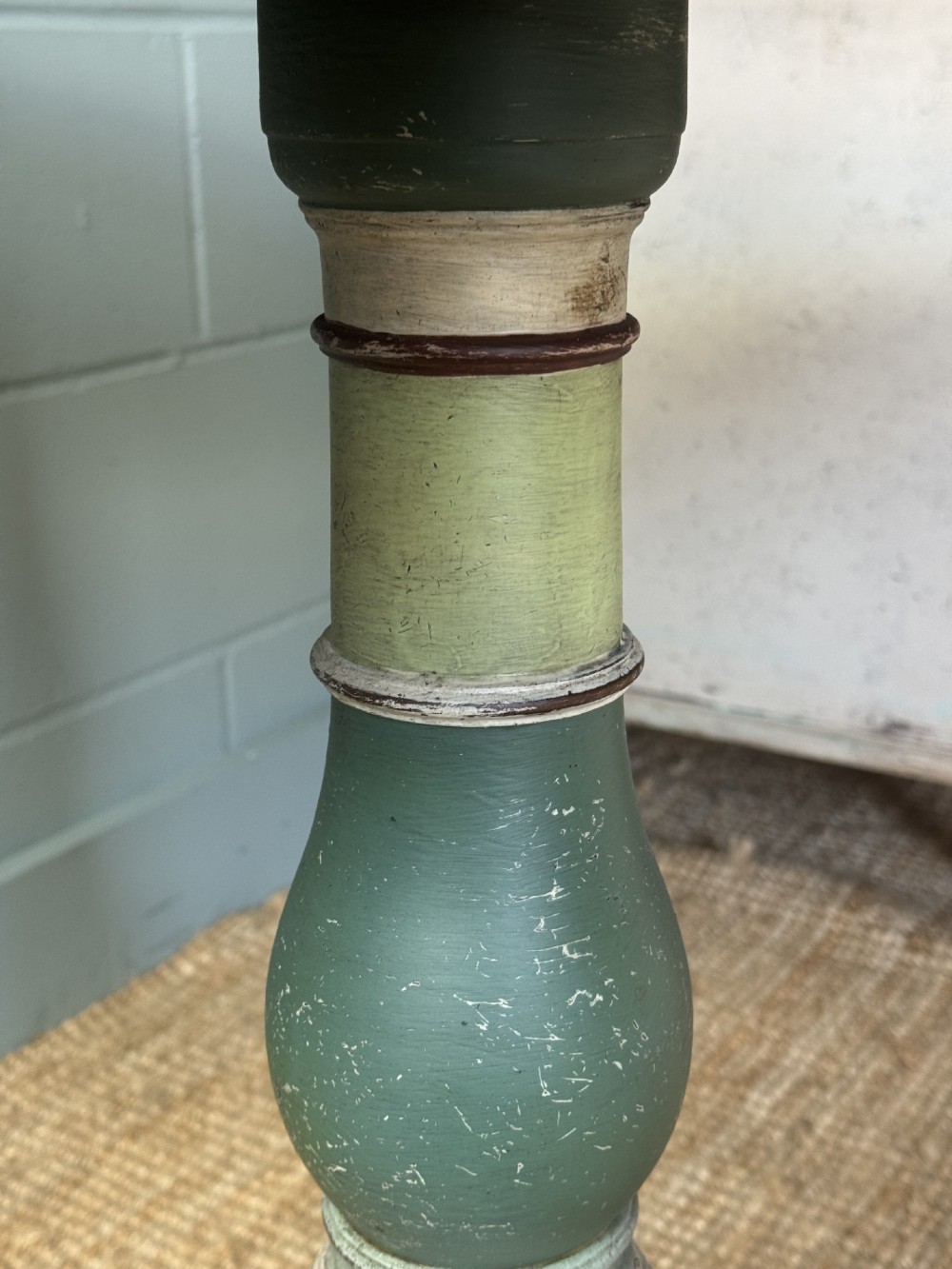 A Victorian circular tilt-top table with a turned tripod pedestal base and hand-painted geometric petal design in green, cream, and black. View IV