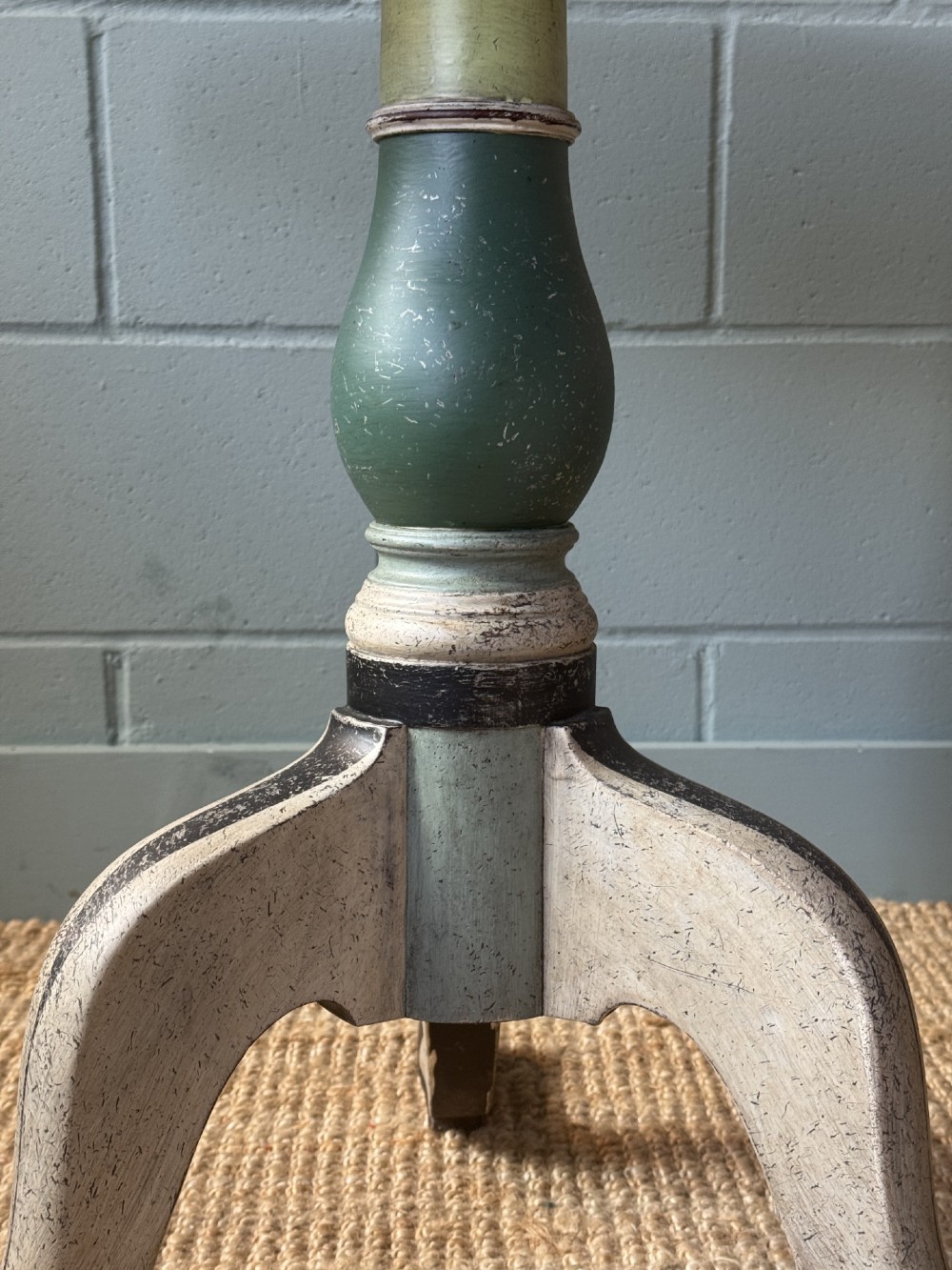 A Victorian circular tilt-top table with a turned tripod pedestal base and hand-painted geometric petal design in green, cream, and black. View VI