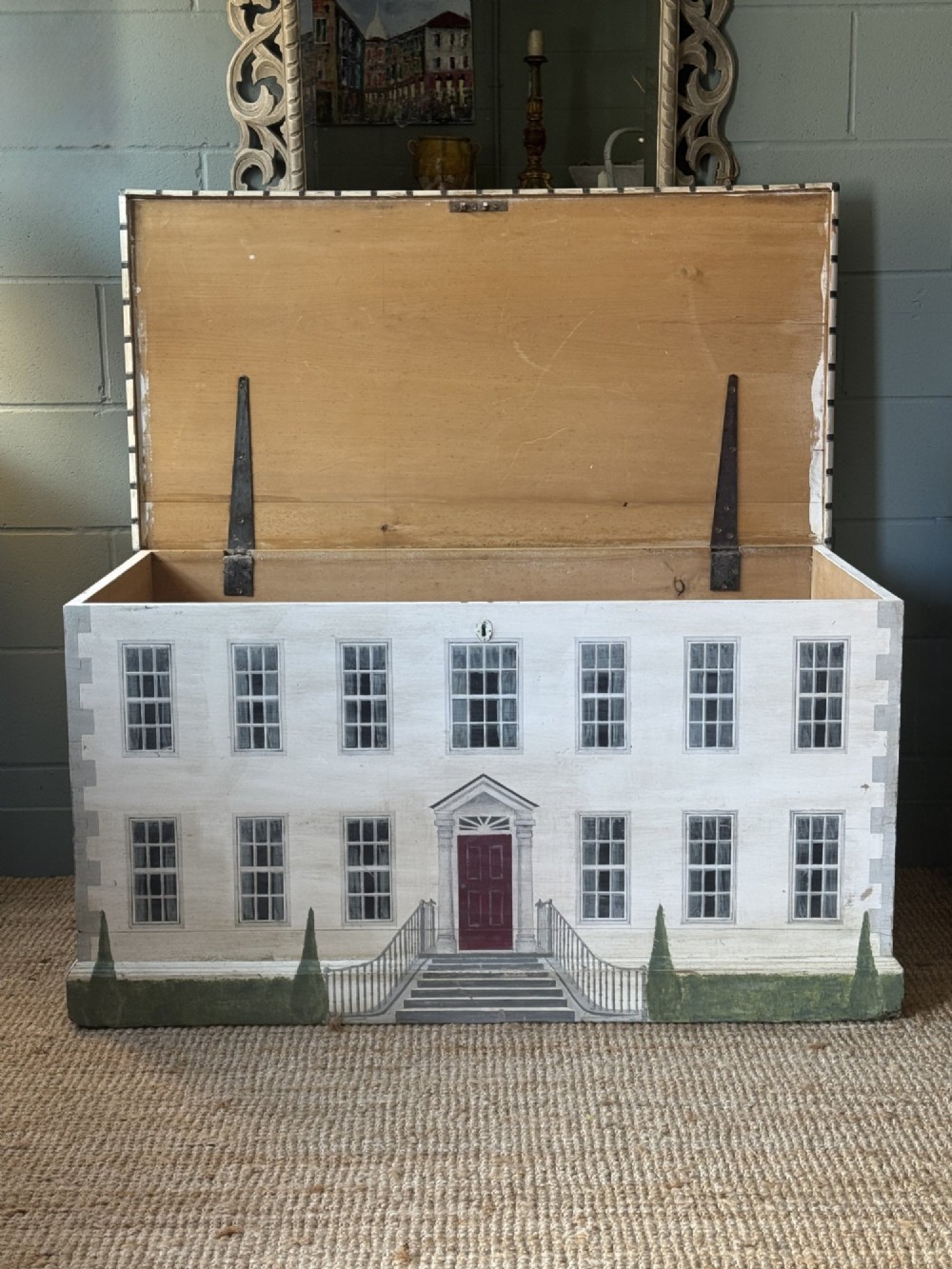 An off-white wooden blanket box hand-painted with a detailed depiction of a Georgian manor house facade featuring a central red door, sash windows, and stone steps. View III