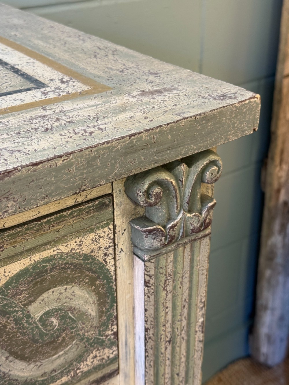 A grey-green hand-painted French Empire chest of drawers featuring guilloche drawer decoration, fluted pilasters, and side cartouche panels. View VII