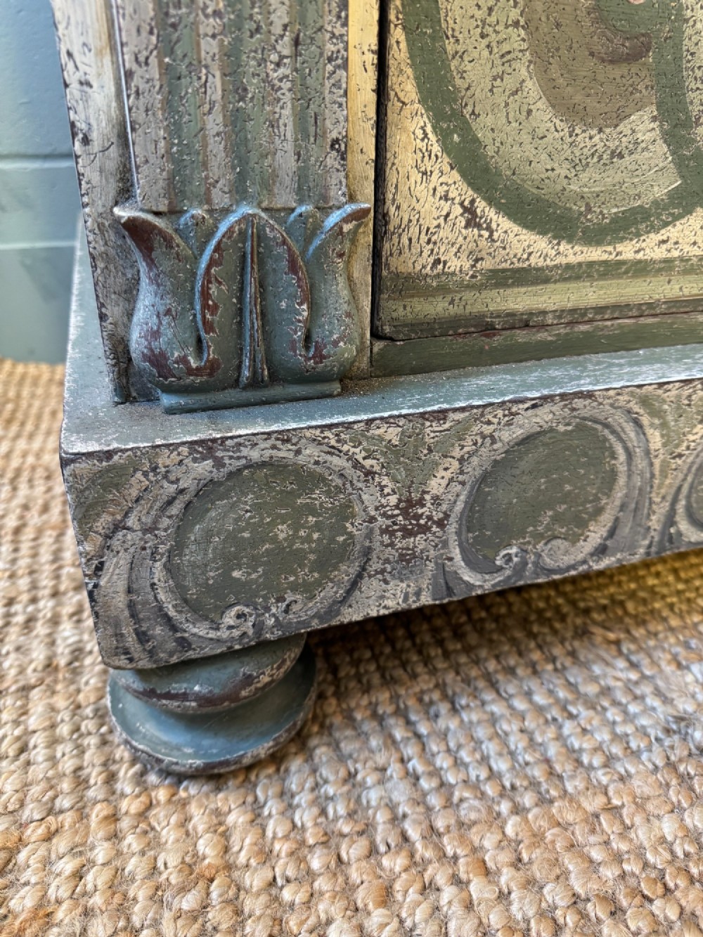 A grey-green hand-painted French Empire chest of drawers featuring guilloche drawer decoration, fluted pilasters, and side cartouche panels. View X