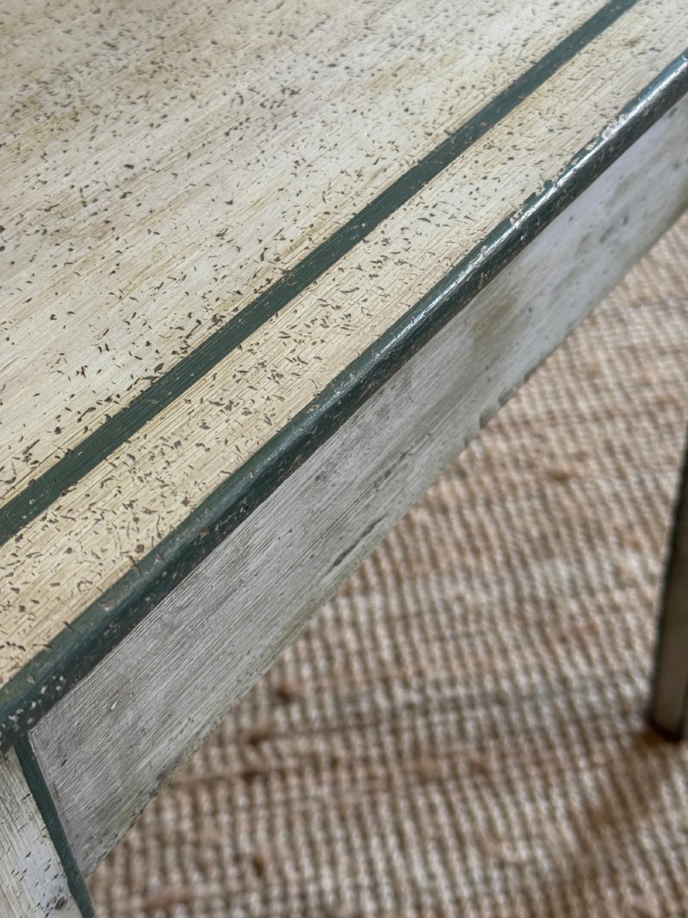 An off-white painted French provincial lamp table with dark trimmed borders, a star motif top, tapered legs, and a single drawer. View VII