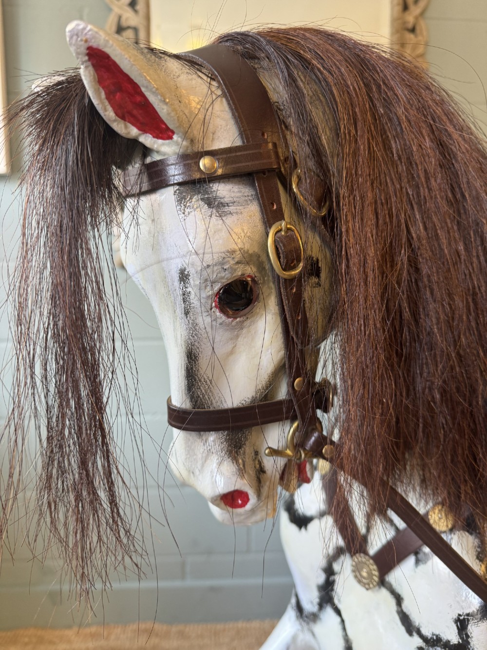 An Edwardian carved wooden dapple grey rocking horse with real horsehair and leather saddle, mounted on a black painted wooden bow rocker. View II