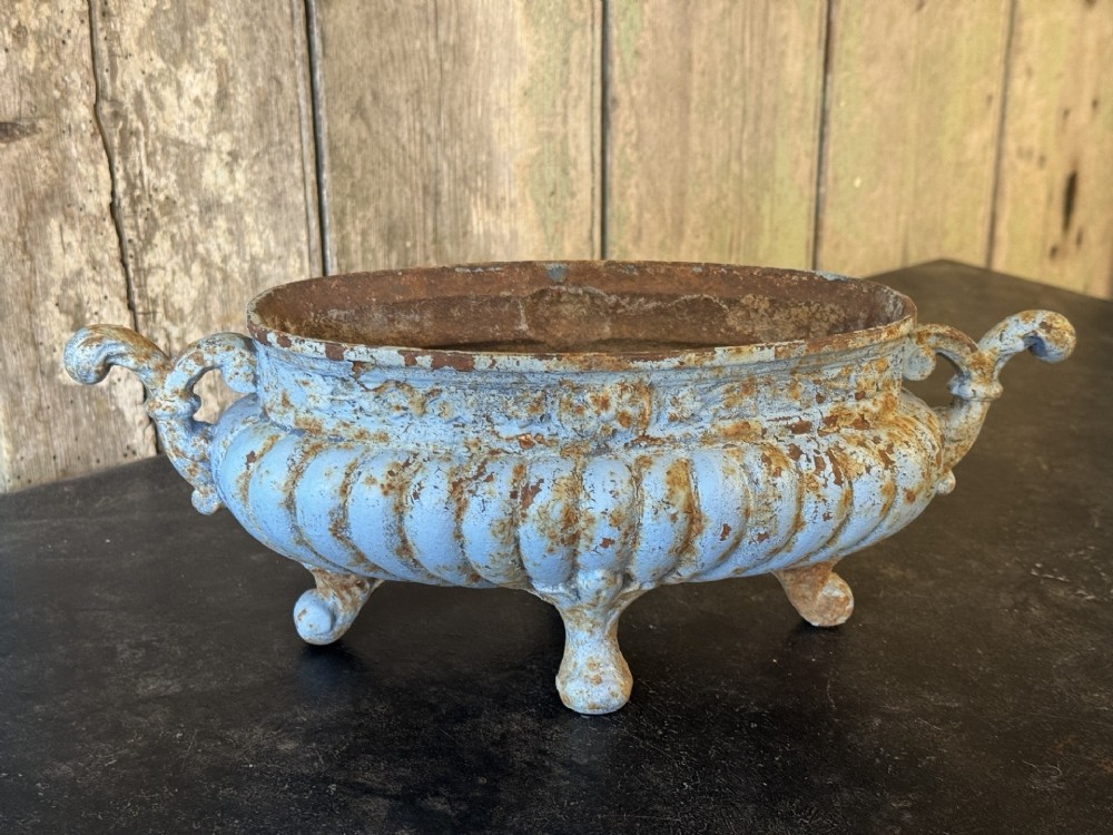 A 19th-century French cast iron jardiniere with fluted details, twin scroll handles, and a distressed pale blue painted surface finish. View IV