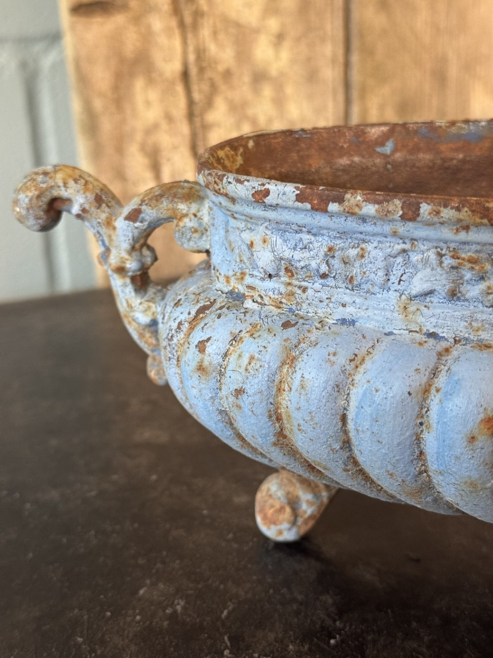 A 19th-century French cast iron jardiniere with fluted details, twin scroll handles, and a distressed pale blue painted surface finish. View V