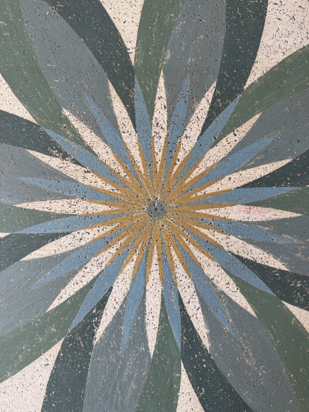 A circular Victorian tilt-top table featuring hand-painted geometric and botanical foliage patterns in green and yellow on a cream ground, resting on a tripod base with brass claw feet. View IX