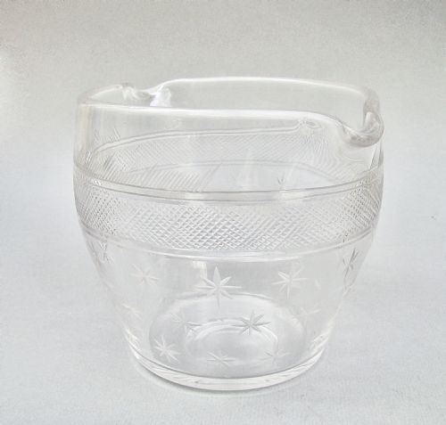 fig 3. A clear late 18th-century Georgian glass rinser featuring twin pouring spouts, a diamond-cut waistband, and starburst motifs etched around the lower bowl.