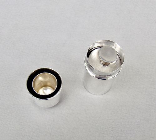 fig 2. A disassembled 1913 sterling silver sewing compendium showing the cylindrical case, tiered thread spool holder, cap lid, and textured thimble.