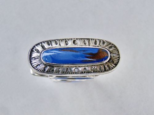 fig 4. An 18th-century French silver travelling etui featuring ornate repousse scrollwork and inlaid blue aventurine panels.