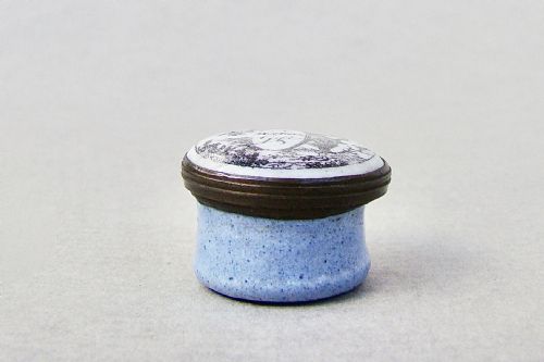 fig 1. A small circular Georgian enamel patch box featuring a light blue base and a hinged white lid with a black transfer-printed urn image and the text A Mothers Gift.