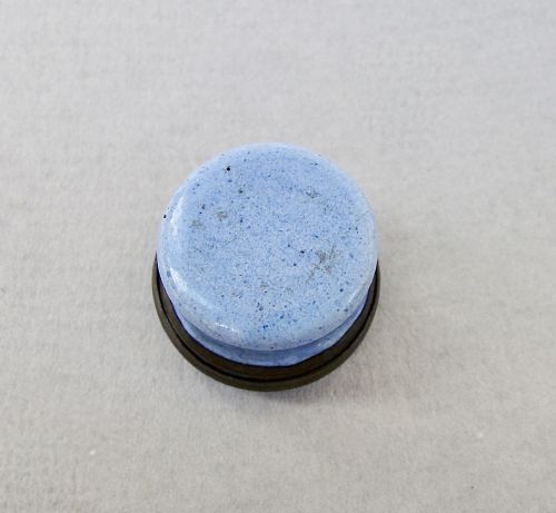 fig 3. A small circular Georgian enamel patch box featuring a light blue base and a hinged white lid with a black transfer-printed urn image and the text A Mothers Gift.