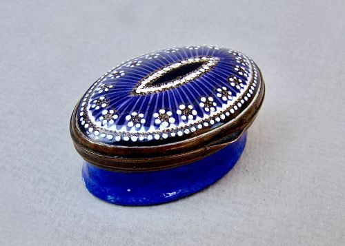 fig 1. An 18th-century oval cobalt blue enamel patch box featuring delicate white dotted patterns and a metal-rimmed hinged lid.