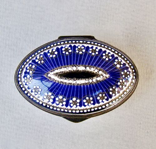 fig 2. An 18th-century oval cobalt blue enamel patch box featuring delicate white dotted patterns and a metal-rimmed hinged lid.