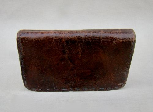 fig 2. A late Victorian dark brown leather purse featuring scroll-patterned silver corner mounts with hallmarks and an oval metal central clasp.