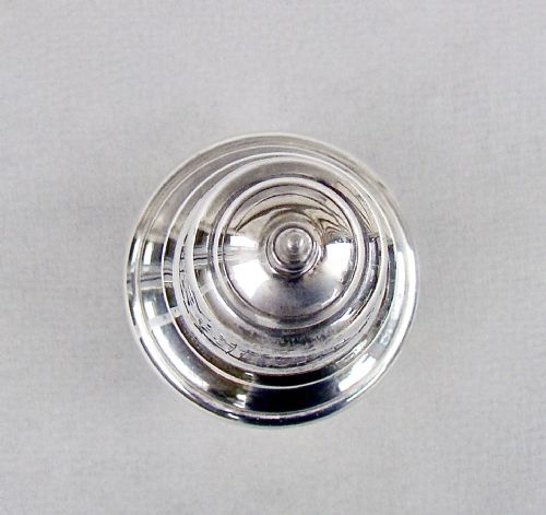 fig 2. A solid silver sugar caster featuring a baluster body, hallmarks on the neck, a pierced dome lid, and a turned finial top.