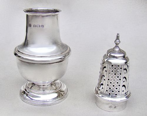 fig 3. A solid silver sugar caster featuring a baluster body, hallmarks on the neck, a pierced dome lid, and a turned finial top.