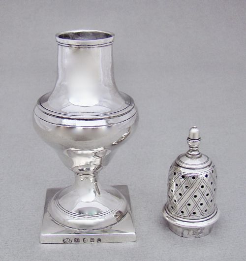 fig 1. A Georgian sterling silver sugar caster featuring a baluster-shaped body, square base, and a pierced lattice lid topped with a finial.