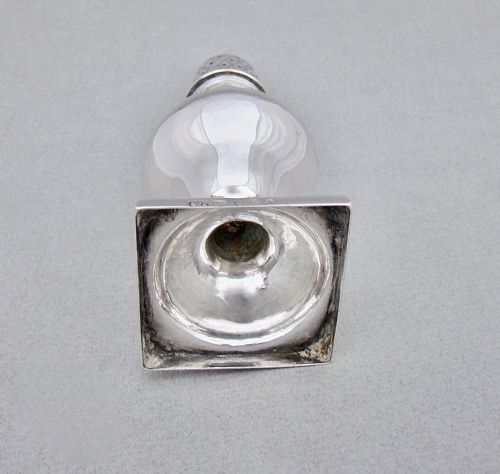 fig 3. A Georgian sterling silver sugar caster featuring a baluster-shaped body, square base, and a pierced lattice lid topped with a finial.