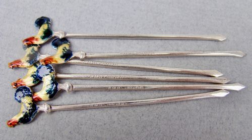 fig 2. A cased set of six sterling silver cocktail sticks featuring colourful enamelled cockerel finials arranged inside a fitted cream-lined presentation box.