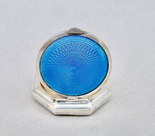 fig 1. An octagonal sterling silver Art Deco compact featuring a central circular panel of bright turquoise blue guilloche enamel with a suspension loop.