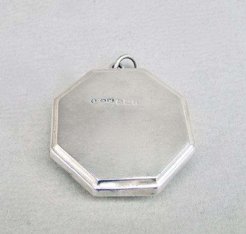 fig 2. An octagonal sterling silver Art Deco compact featuring a central circular panel of bright turquoise blue guilloche enamel with a suspension loop.