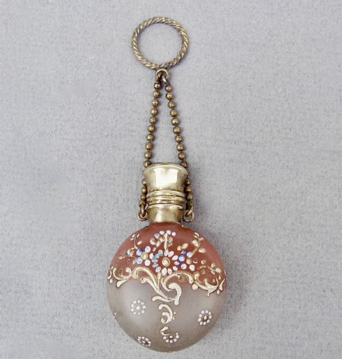 fig 1. A nineteenth-century French satin glass chatelaine scent bottle decorated with hand-applied enamel scrolls and flowers, fitted with a gilded metal cap and chain.